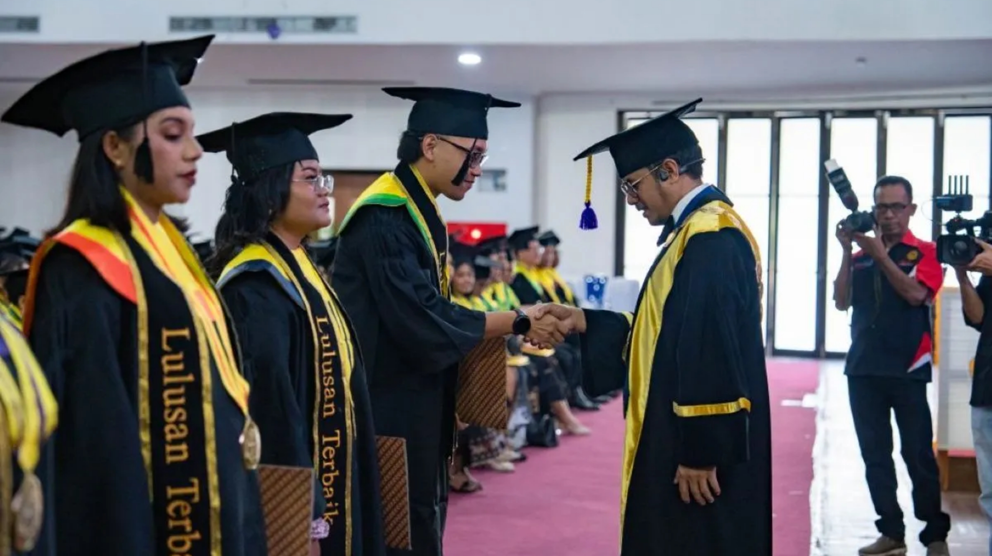 Rektor Universitas Nusa Cendana Jefri S. Bale memberikan selamat kepada sejumlah mahasiswa yang diwisuda di Kupang. (IDNVoice/Undana) 