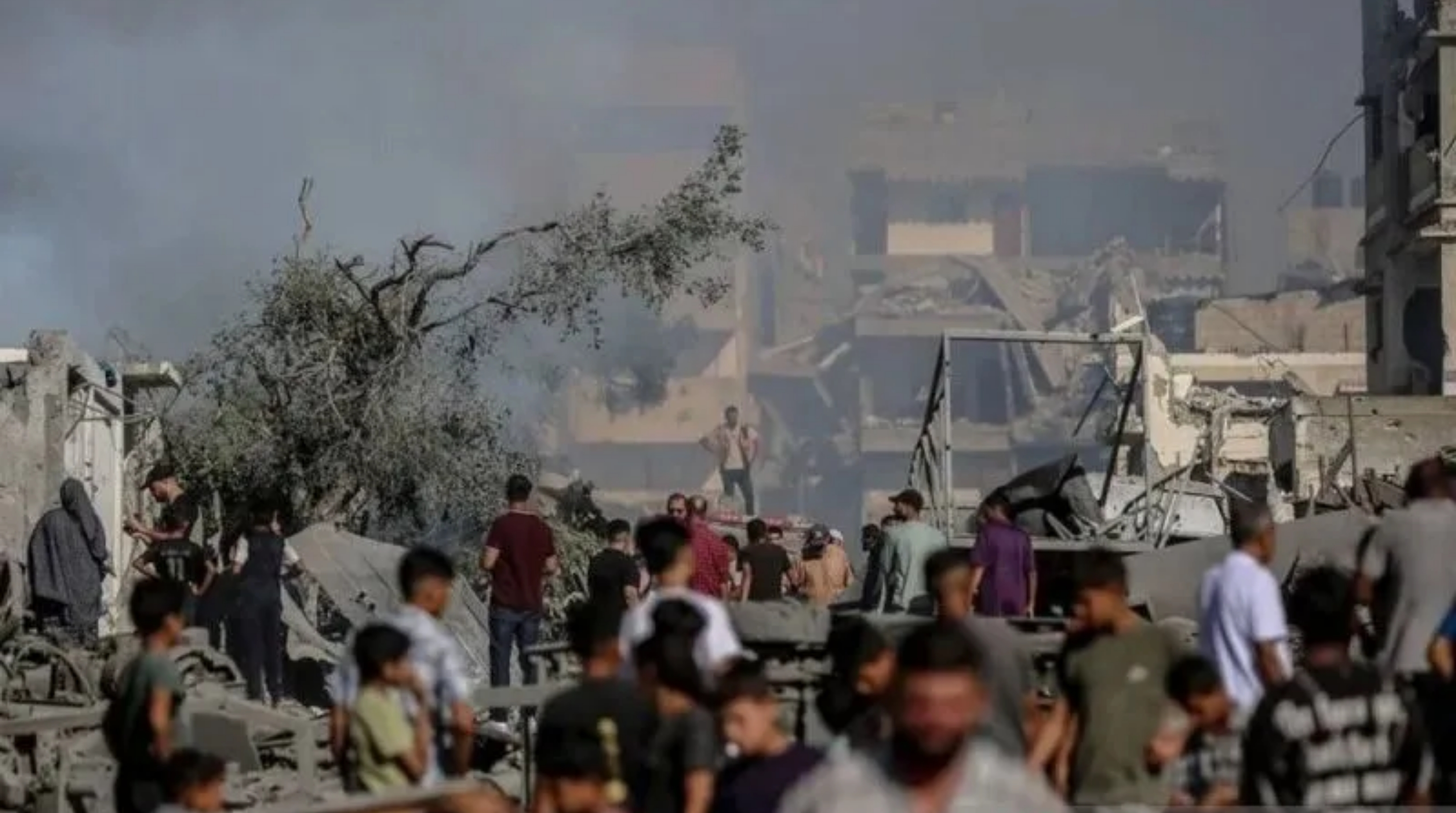 Warga Palestina berlarian saat asap membubung di tengah puing-puing dan kehancuran di Jalan Al-Sinaa (Kawasan Industri) di bagian barat Kota Gaza pada 12 Juli 2026. (IDNVoice/Anadolu Agency)