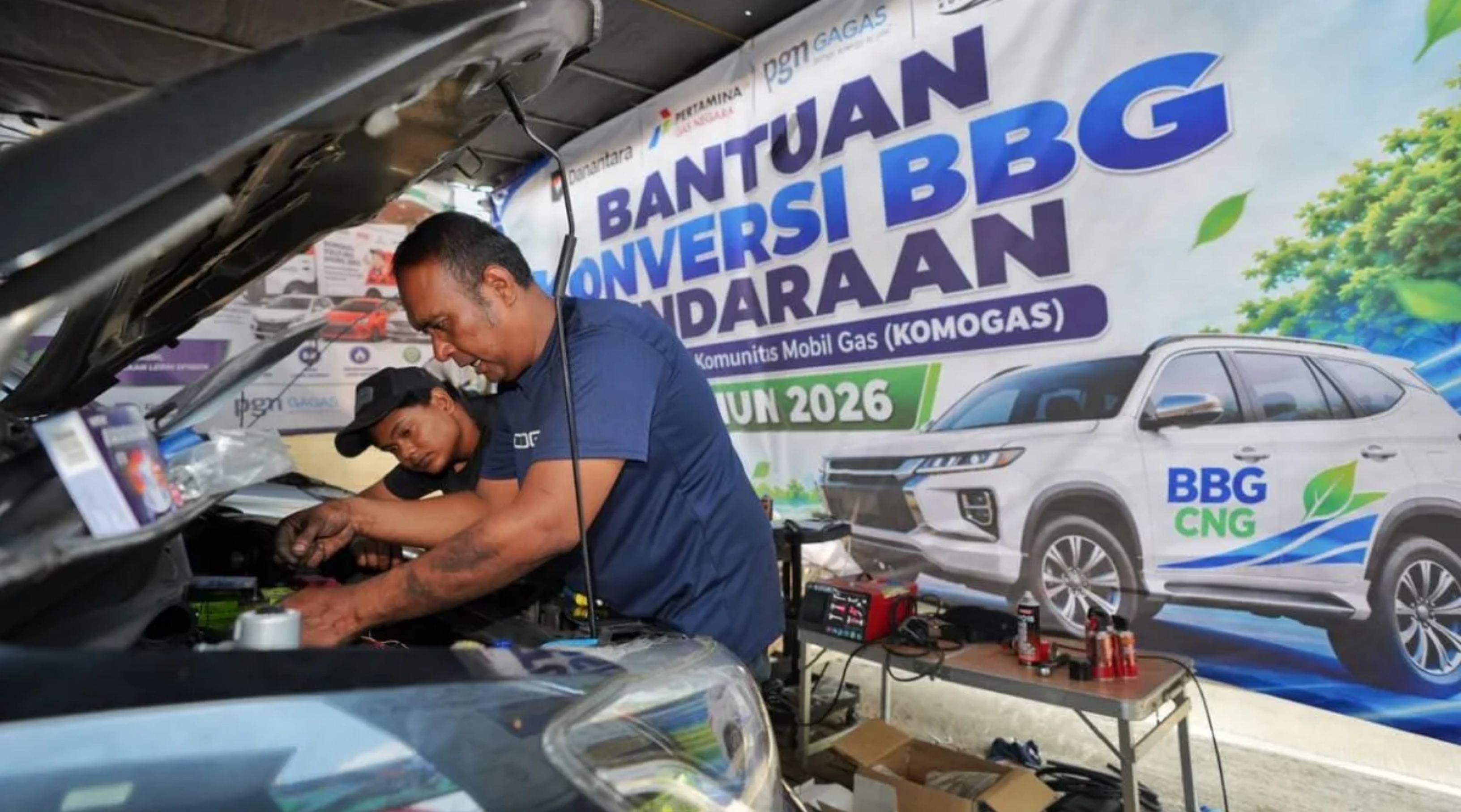 Seorang petugas sedang memasang kit bahan bakar gas (BBG) pada kendaraan taksi online dalam Program Bantuan Konversi BBG Kendaraan 2026 yang digelar PT Perusahaan Gas Negara (PGN). (IDNVoice/PGN)