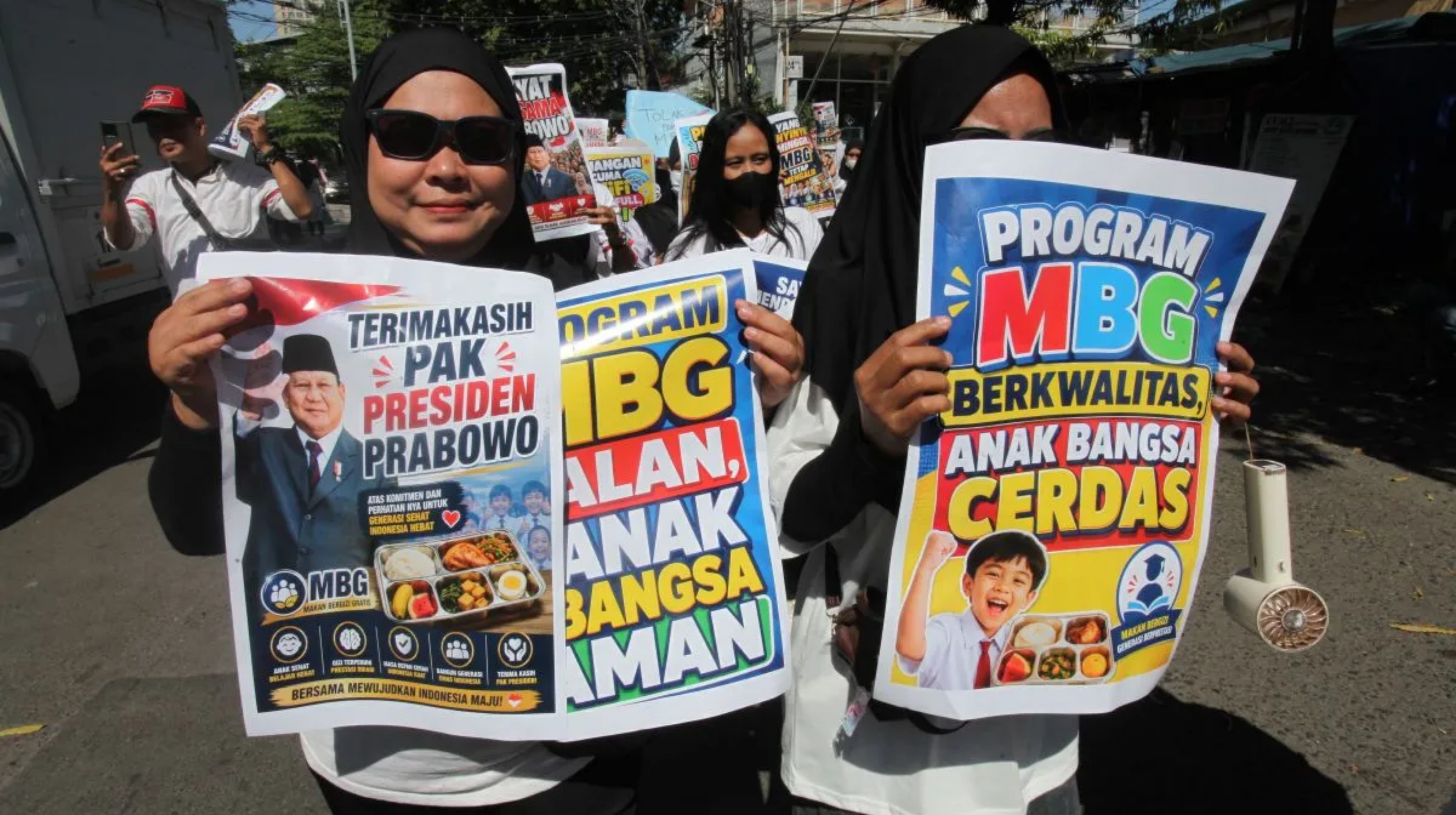 Sejumlah massa aksi damai membentangkan poster dukungan keberlanjutan program MBG di depan Gedung Negara Grahadi, Surabaya pada Rabu, 8 Juli 2026. (IDNVoice/Antara Foto)