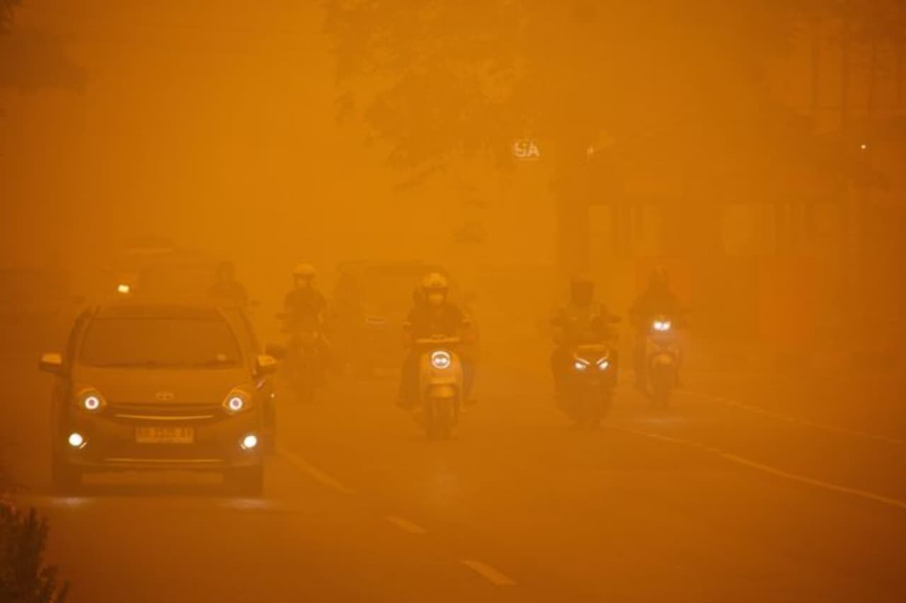 Para pengendara melintasi jalan utama saat kabut asap akibat kebakaran hutan dan lahan (karhutla) menyelimuti Kota Palangka Raya di provinsi Kalimantan Tengah (Kalteng). (IDNVoice/Reuters)